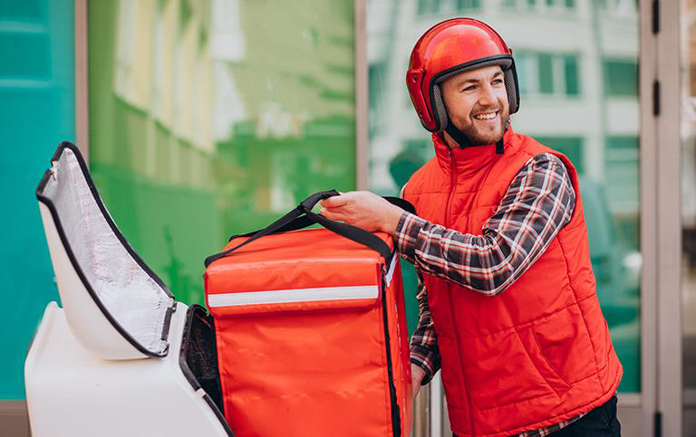 Professional delivery rider beside an insulated delivery bag